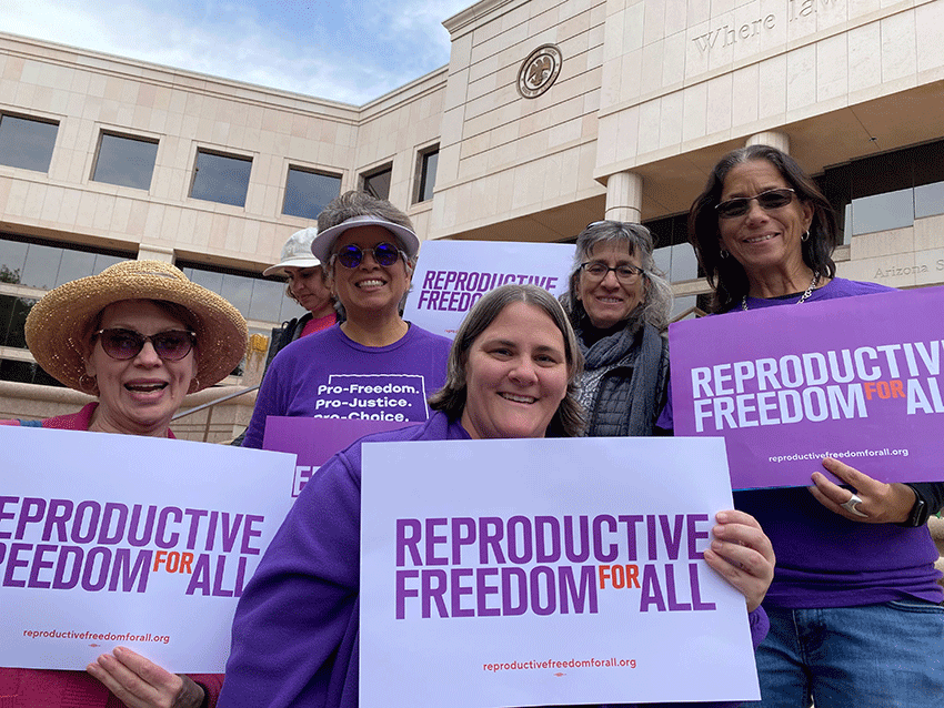 Nevadans pose for a group photo holding Reproductive Freedom for All signs at the state capitol