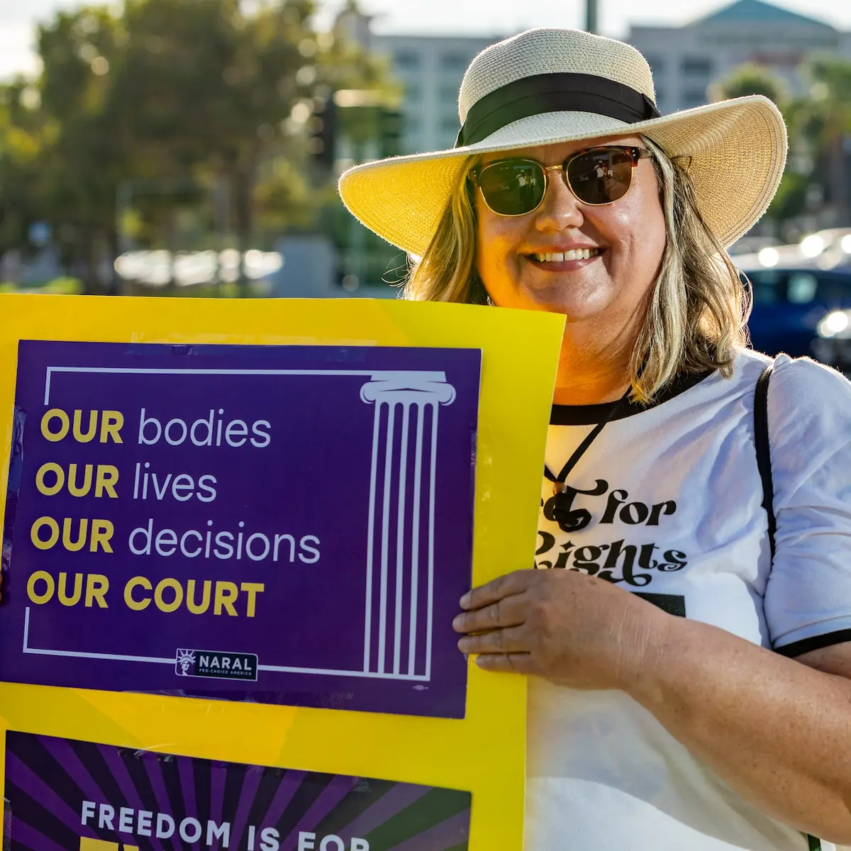 A supporter holding a sign that reads our bodies our lives our decisions our court