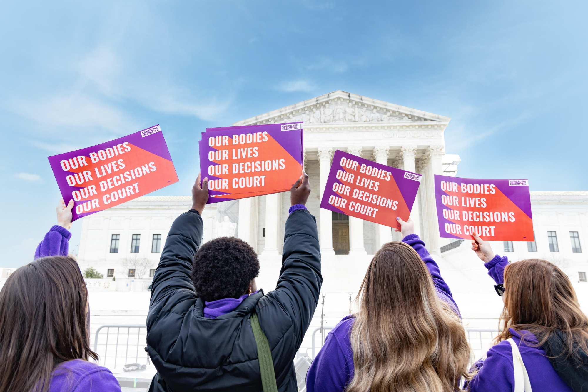 Reproductive Freedom for All members holding signs in front of SCOTUS that say "Our Bodies, Our Lives, Our Decisions, Our Court"